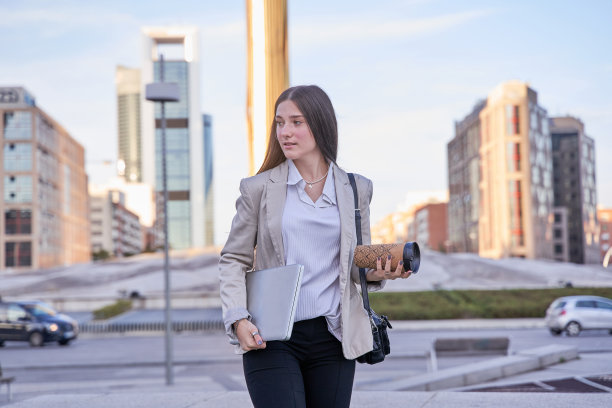 年轻的学生走着他的笔记本电脑图片下载