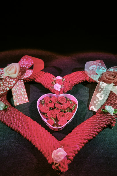 用绳子、丝带和玫瑰做成的心形，中间是另一颗装满玫瑰的心。图片下载