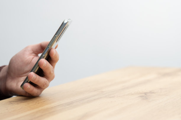 男子手持智能手机。男子用智能手机，用一根手指指着屏幕图片下载