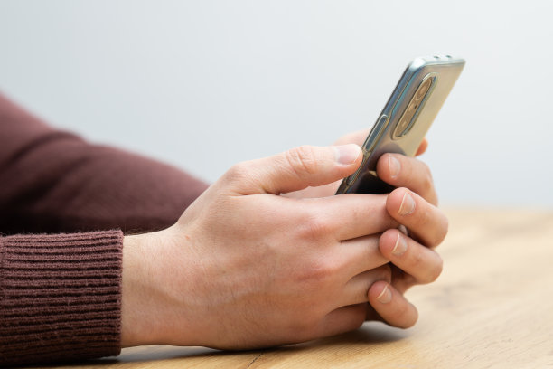 男子手持智能手机。男子用智能手机，用一根手指指着屏幕图片下载