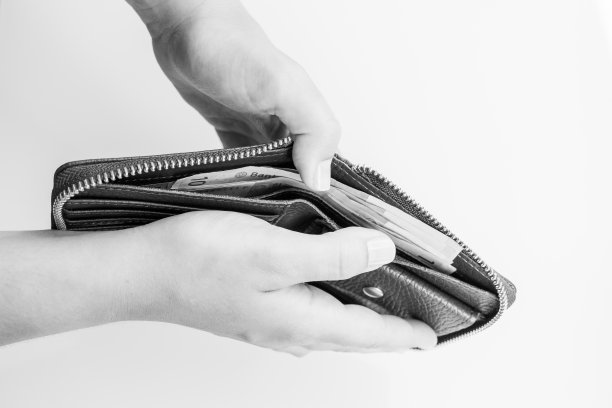 女性的手从白色背景的钱包中取出钱图片下载