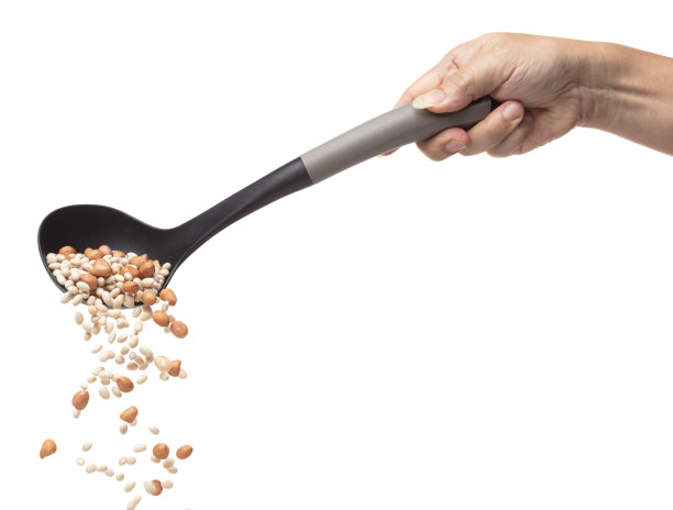 拌白花生豆落爆，几种豆浮倒在大勺里。干白花生杂豆在空气中飞溅。白色背景隔离高速快门冻结运动图片下载