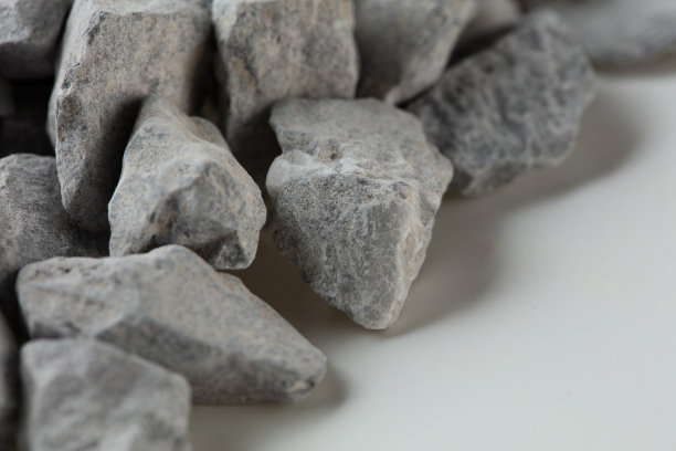 施工砾石堆石群卧，灰岩砾石呈现近距离纹理和粉尘，对象设计。白色背景隔离冻结镜头图片下载