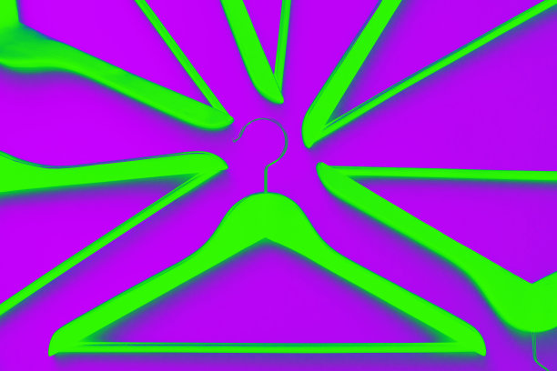 紫色背景上的霓虹绿色木制衣架。销售和购物概念。现代时尚。图片下载