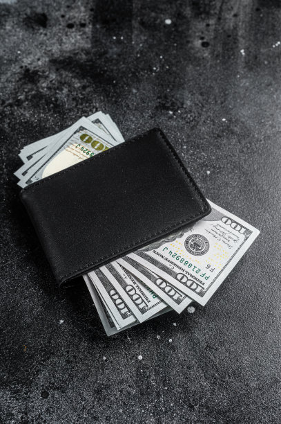 一个黑色钱包，里面有一大袋美元，现金或美钞。黑色背景。前视图。本空间图片下载