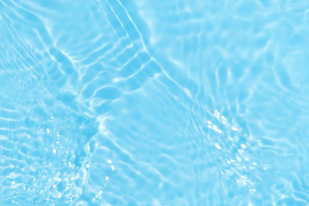 离焦模糊透明蓝色颜色清晰平静的水面纹理与飞溅和气泡。潮流抽象的自然背景。水波在阳光下复制空间。蓝色水彩闪光图片下载