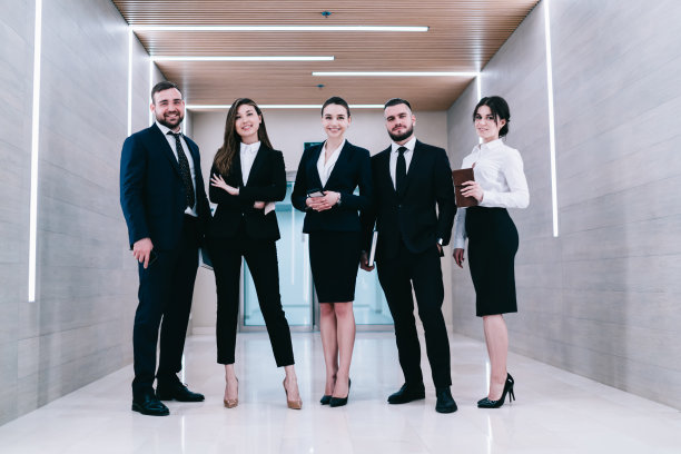 快乐的同事站在明亮的走廊图片下载