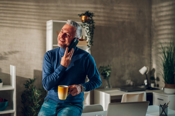 中年男子在家里用智能手机喝咖啡图片下载