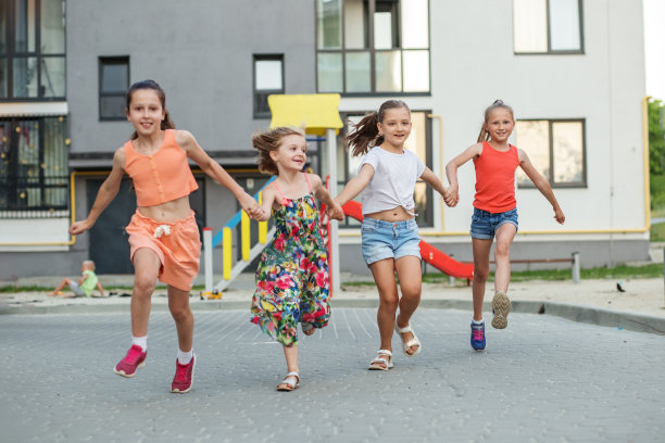 一群女孩围着操场跑，玩得很开心。童年，闲暇，友谊的概念图片下载