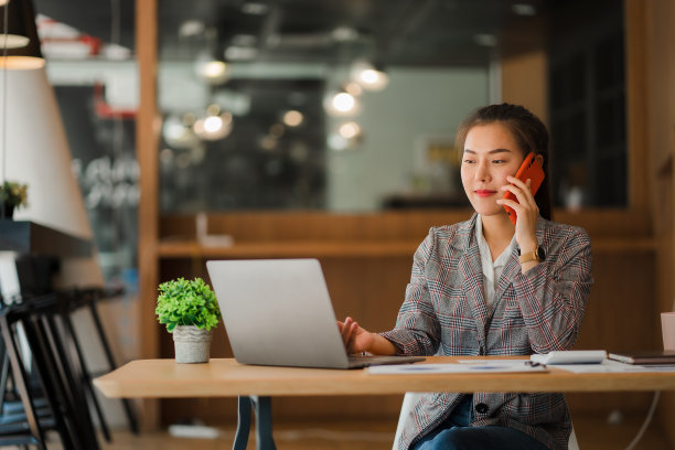亚洲女商人在笔记本电脑上工作，年轻女子的财务文件在办公室垂直图片中显示和工作在财务和计算器上图片下载