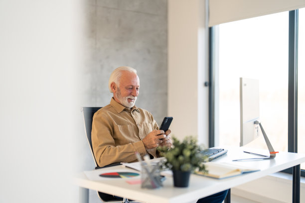高级商人企业家看着智能手机。业务平台应用技术概念图片下载