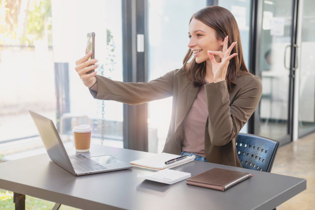 销售，财务，会计，计划，双语女商人正在与代表公司分销商的客户交谈，她在办公桌上用智能手机和笔记本电脑笔和记事本。图片下载