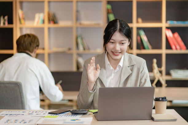 有吸引力和有吸引力的亚洲女性会议在笔记本电脑上的视频通话与团队的朋友坐在后面的财务会计概念。图片下载