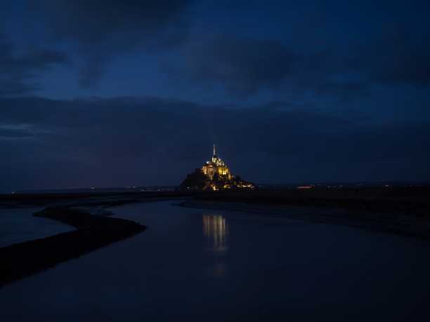 法国诺曼底著名的偏僻孤岛岩石城堡小镇圣米歇尔山全景景观夜景图片下载