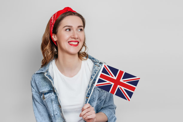 国外的教育。女学生拿着英国国旗，微笑着看向远处的白色背景图片下载
