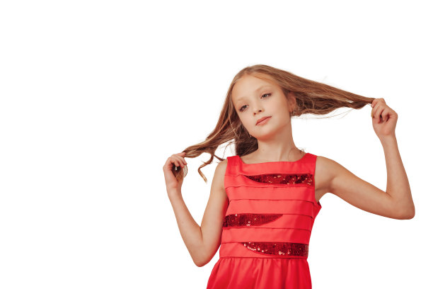 时尚的小女孩模特肖像在粉红色连衣裙在孤立的空白色背景，看着相机。可爱的女孩在工作室拍摄摆姿势。造型的概念。复制广告的文本空间图片下载