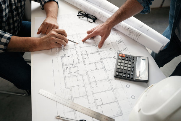 建筑师和工程师在桌子上讨论蓝图-手部特写和项目打印。图片下载