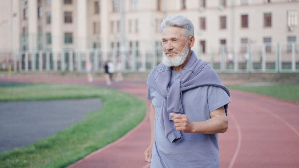 老人在体育馆里跑步。爷爷慢跑竞技场。老年运动员锻炼。图片下载