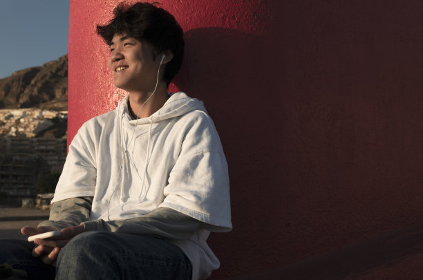 亚洲少年在户外戴耳机图片下载