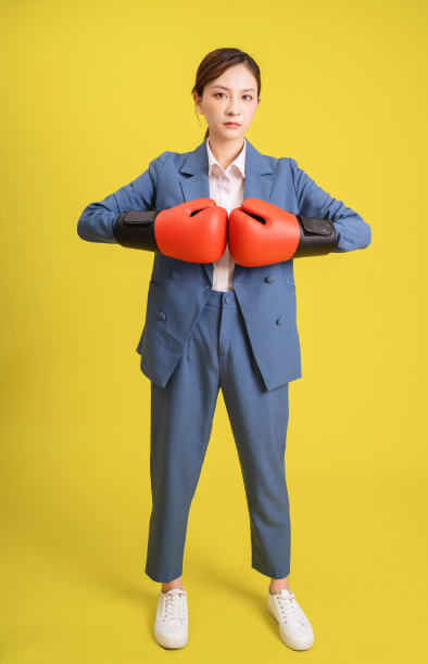 年轻的亚洲女商人的形象与拳击手套图片下载