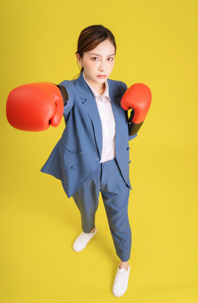 年轻的亚洲女商人的形象与拳击手套图片下载