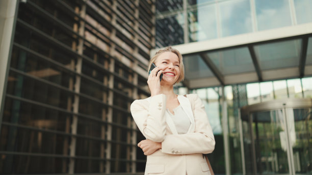 金发的快乐女商人在商业中心背景上打电话，好交易，成功图片下载