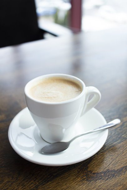 咖啡馆的木桌上有一杯白色的拿铁咖啡图片下载