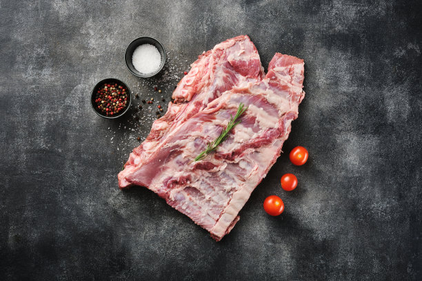 生排骨加香料，盐，胡椒和迷迭香。新鲜的猪肉。猪排骨。图片下载