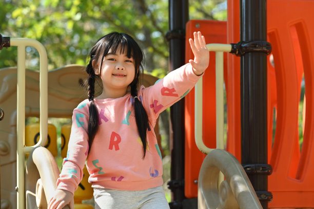 可爱的亚洲小女孩在夏天的白天在操场上玩耍。图片下载