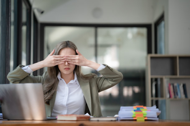 亚洲女商人感到筋疲力尽，在办公室里捂着眼睛。图片下载