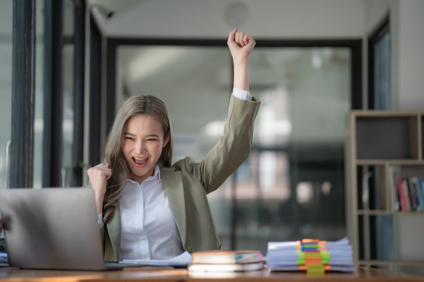 亚洲女性在笔记本电脑上庆祝赢得或获得电子商务购物优惠。兴奋快乐的女孩获胜者看着笔记本庆祝成功。图片下载