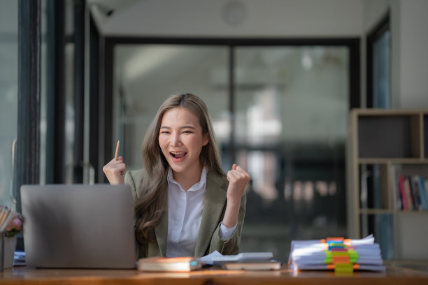 亚洲女性在笔记本电脑上庆祝赢得或获得电子商务购物优惠。兴奋快乐的女孩获胜者看着笔记本庆祝成功。图片下载