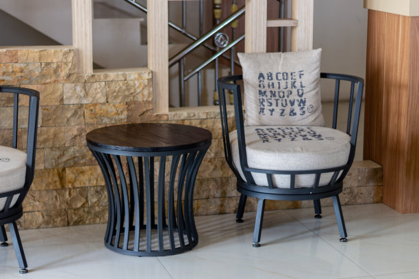 皮革扶手椅和咖啡桌。客厅设计，扶手椅和圆桌。图片下载