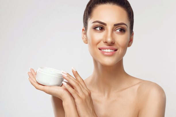 年轻女子拿着美容保湿霜。柔软的皮肤和裸露的肩膀，模型与光裸妆，女孩的脸与清洁健康的皮肤肖像。图片下载