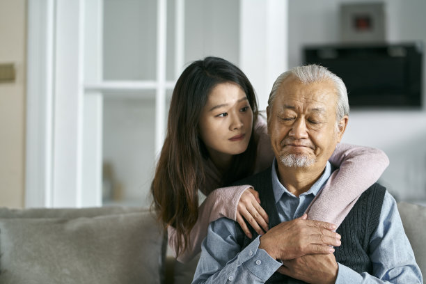 年轻的亚洲成年女儿在家安慰年迈的父亲图片下载