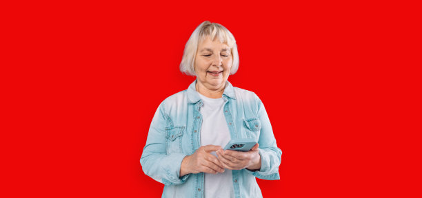 图片是一名成年女性，金发，穿着白色衬衫，手持手机，红色背景图片下载