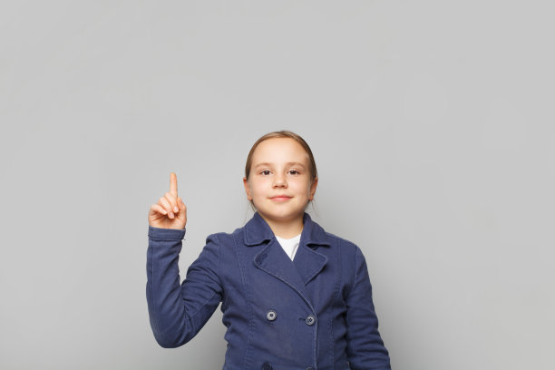 聪明的小孩子学校女孩指向白色的工作室墙横幅背景与复制空间图片下载