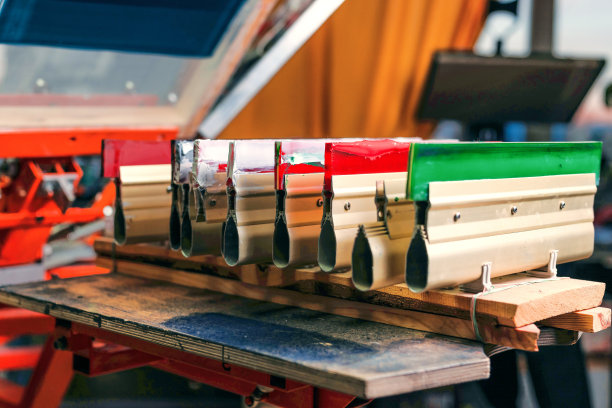 丝网印刷。印刷筛分装置木架上的刮刀。绢印生产。在设计工作室用丝印方法在t恤上印刷图像图片下载