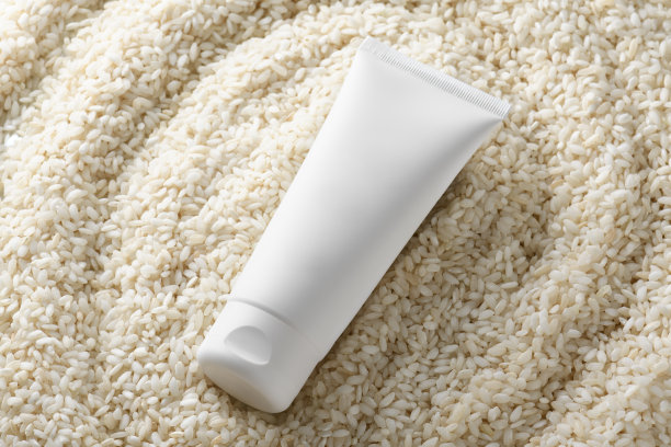 白色挤压瓶塑料管模型的药物或化妆品在白米背景。护肤品模型图片下载