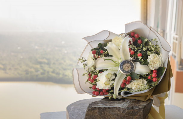 把模拟怀表放在中间的花束上，放在房间阳台上的大石头或黑色岩石上。图片下载