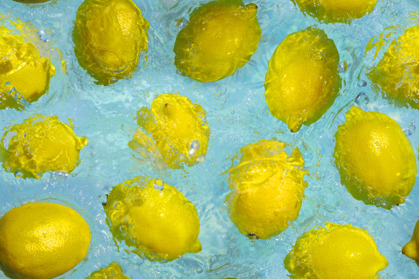 在蓝色的水中浸泡成熟的黄柠檬。无缝模式。图片下载