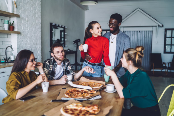 高兴的朋友们在家里微笑着喝着咖啡和披萨图片下载