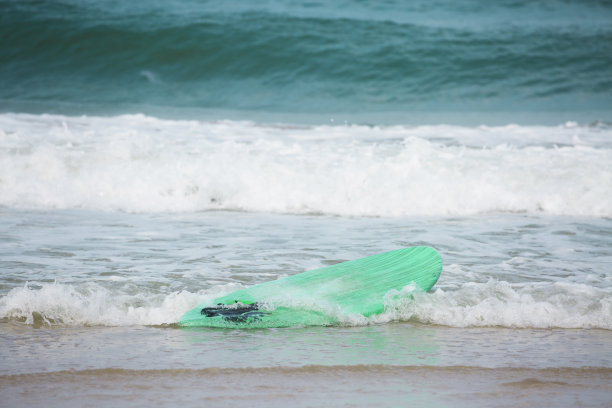 海浪冲上岸的冲浪板图片下载