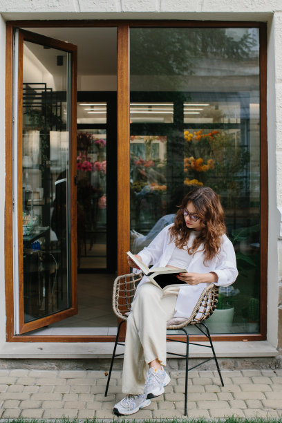 杂志或书籍的形象模型。一个年轻的时髦女孩在一家舒适的咖啡店里看杂志。图片下载