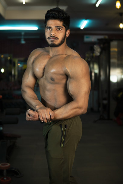 赤膊的印度健美运动员在健身房展示肌肉姿势。图片下载