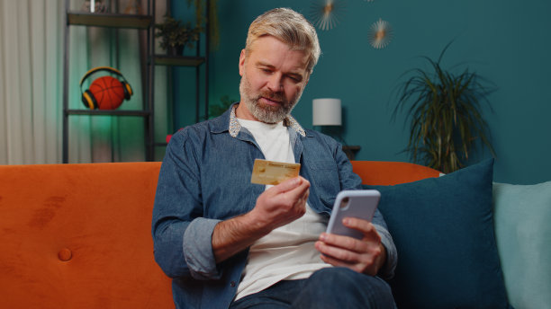中年男子用信用卡和智能手机转账，在网上购物图片下载