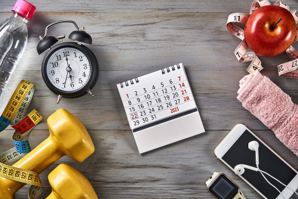 俯视图时钟，卷尺，水瓶，日历，苹果，毛巾和哑铃在桌子上复制空间图片下载
