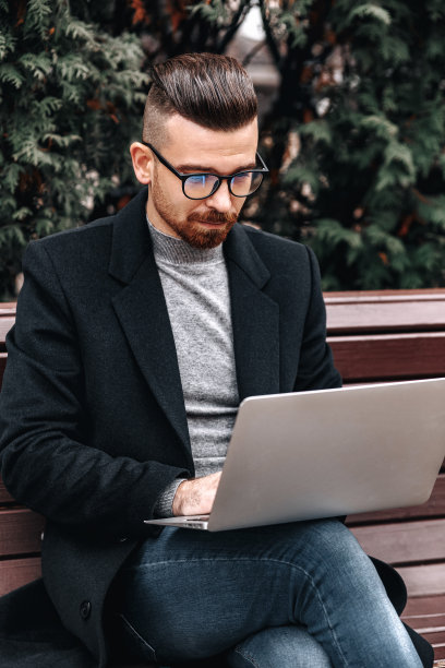 优雅的商人在城市使用笔记本电脑的肖像图片下载