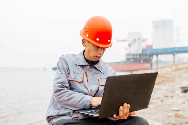 一名男性工程师在码头使用笔记本电脑记录数据并指挥工作图片下载