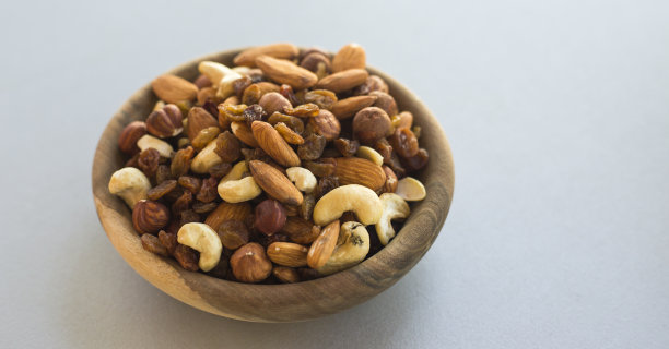 照片的不同类型的坚果在一个盘子在一个灰色的桌子上图片下载